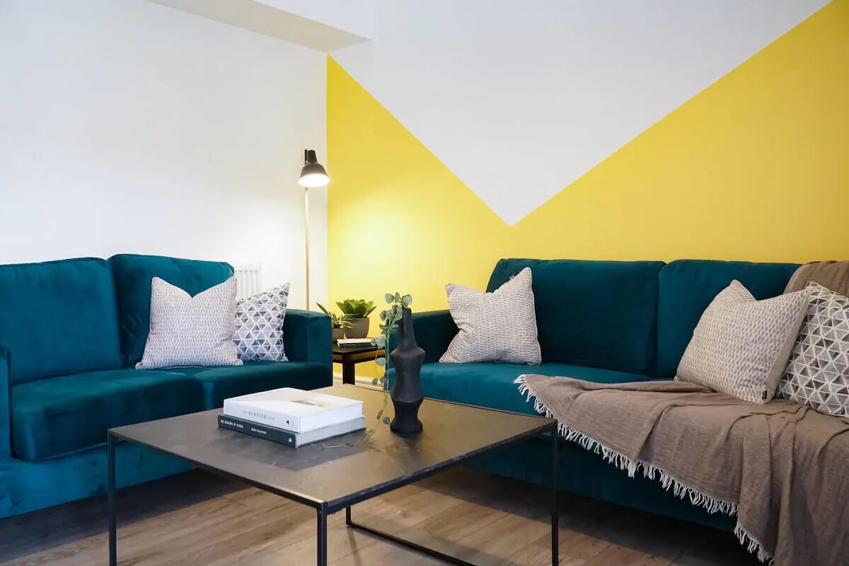 Two teal sofas with patterned pillows living room at 7 Bedroom House at 146, West Parade in Lincoln Student Accommodation