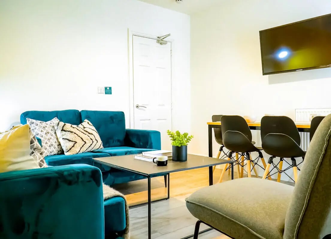 Turquoise sofa with patterned pillows coffee table living room at 6 Bedroom House at 148, West Parade in Lincoln Student Accommodation