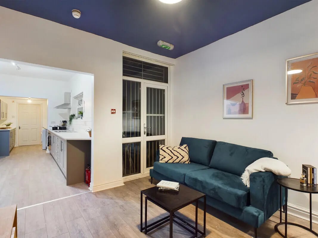 Teal sofa, two coffee tables, kitchen living room at 6 Bedroom House at 10, Richmond Road in Lincoln Student Accommodation
