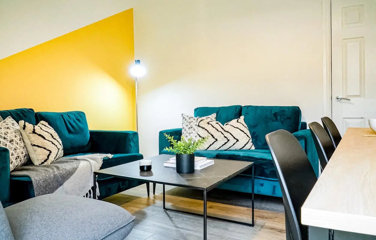 Teal sofas coffee table chairs living room at 6 Bedroom House at 232, West Parade in Lincoln Student Accommodation