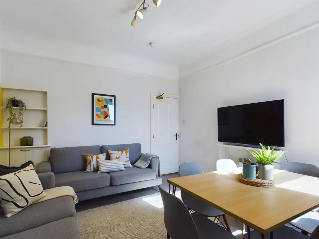 Gray sofa and dining table living room at 6 Bedroom House at 73, West Parade in Lincoln Student Accommodation