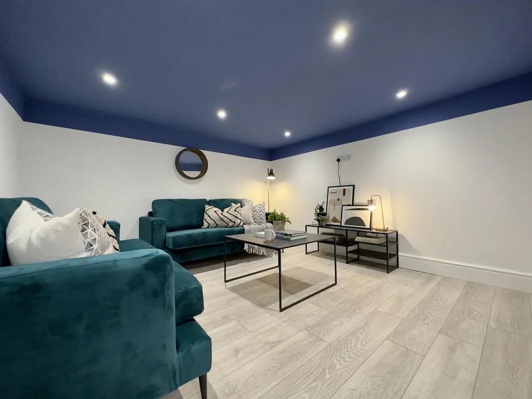 Teal sofas coffee table artwork living room at 6 Bedroom House at 43, Monks Road in Lincoln Student Accommodation