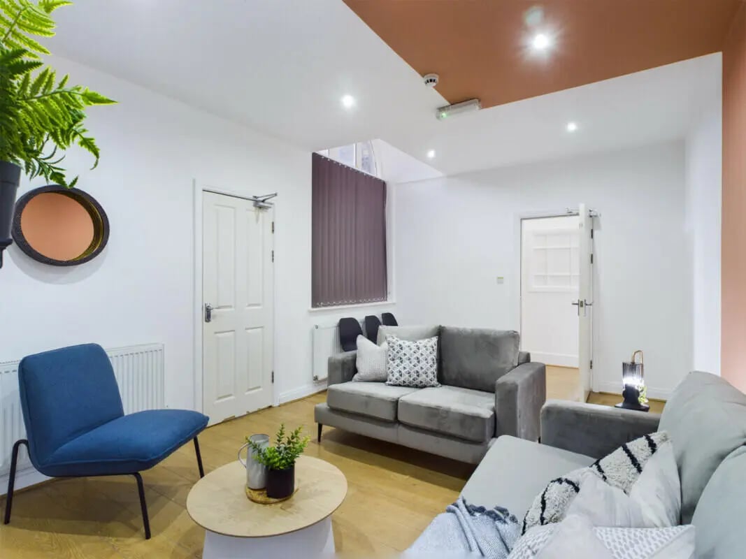 Grey sofas blue chair round table living room at 7 Bedroom House at 6, Well Meadow Drive in Sheffield Student Accommodation