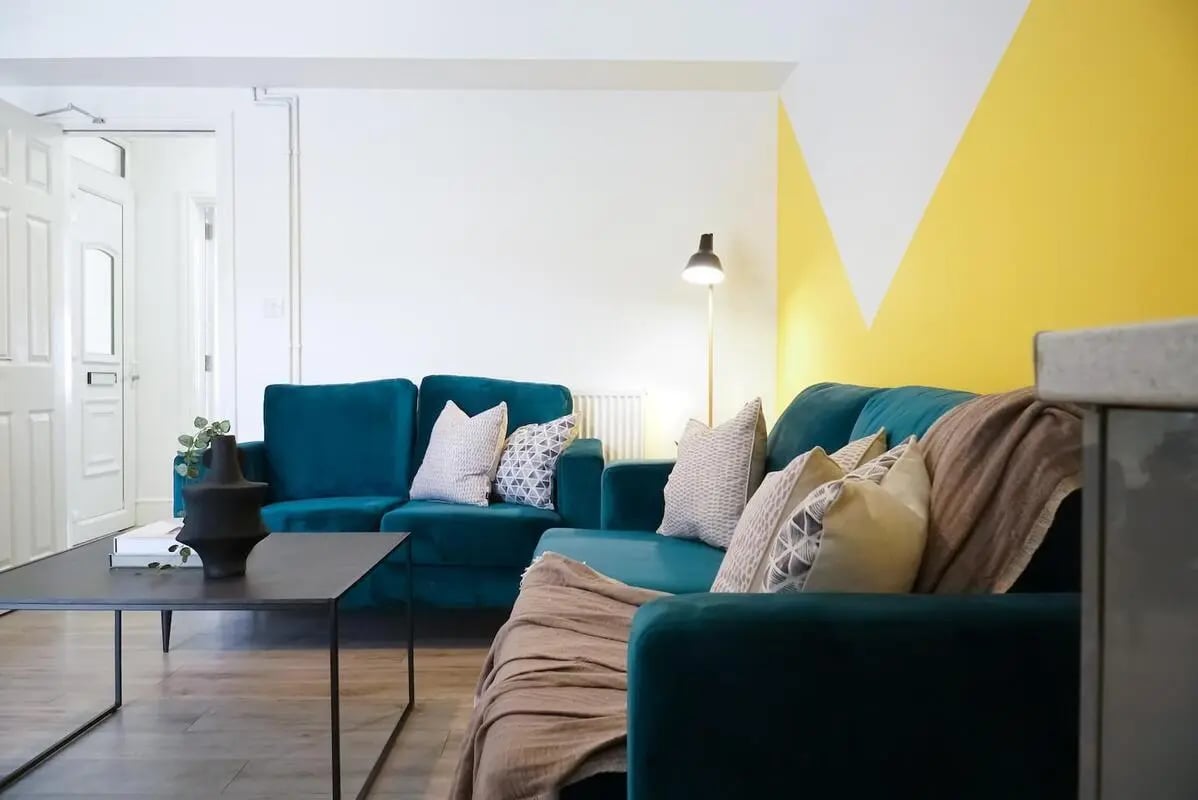 Teal sectional sofa with throw pillows living room at 6 Bedroom House at 23, Haydn Avenue in Manchester Student Accommodation