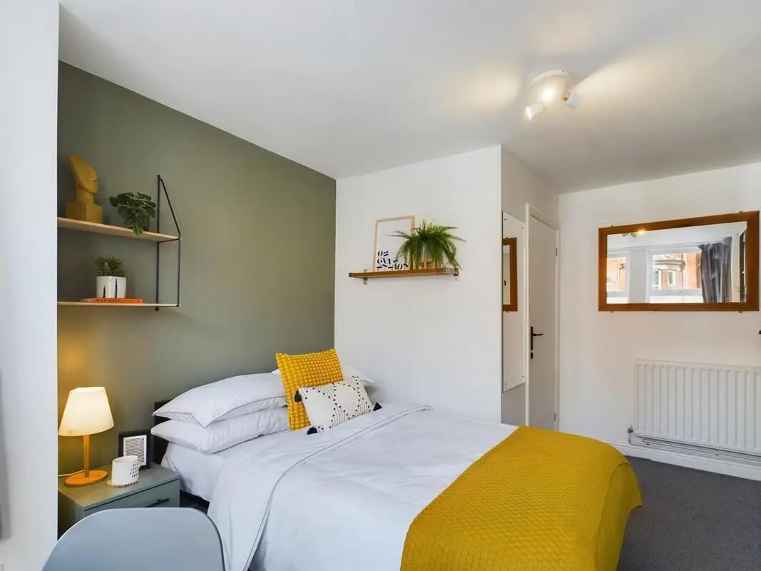 Bed with yellow blanket and pillows bedroom at 4 Bedroom House at 75, West Parade in Lincoln Student Accommodation