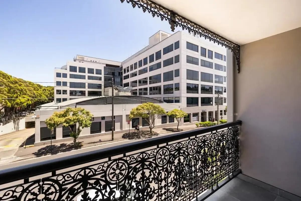 Ornate balcony railing with city buildings and trees exterior at UKO Redfern in Sydney Student Accommodation