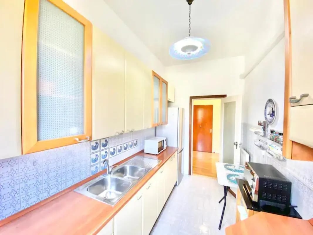 Sink microwave refrigerator and cabinets kitchen at Appartamento soleggiato con ampia terrazza, giardino e parcheggio in Sant'Agnello Student Accommodation