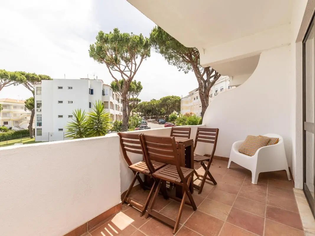 Wooden table chairs white chair balcony exterior at Nice 1-bedroom flat in Faro in Faro Student Accommodation