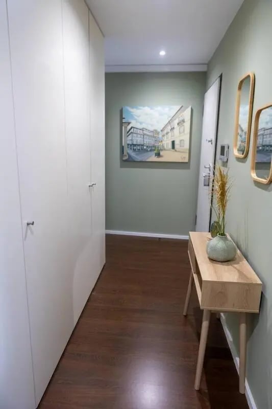 Tall white closet, console table, vase, entryway at Elegant and functional studio in the historic center of Guimarães in Guimaraes Student Accommodation