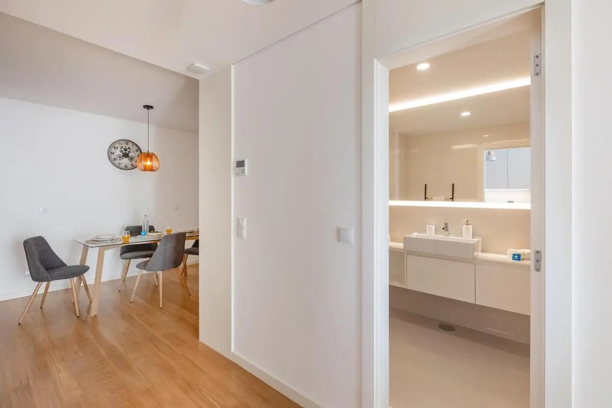 Dining area with table chairs and clock bathroom Image Type at Spacious and bright studio in the vicinity of Matosinhos Beach in Matosinhos Student Accommodation