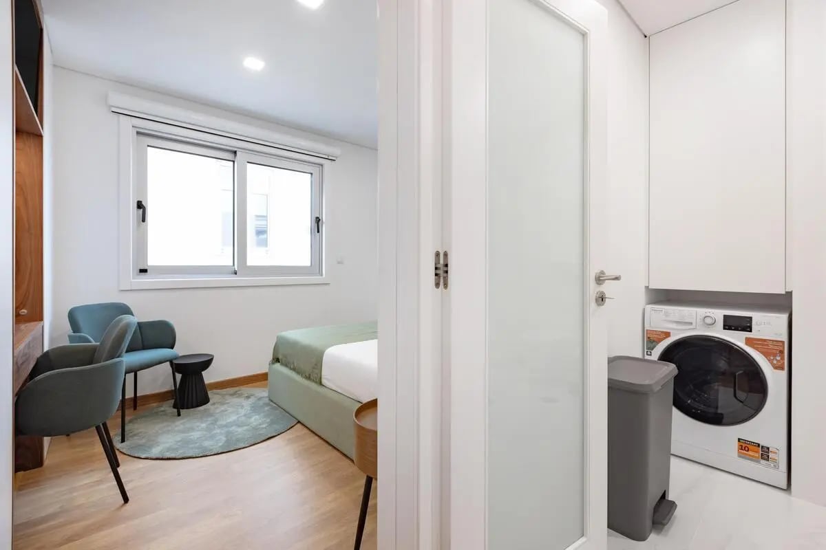 Bed chairs and washing machine bedroom study area at Charming studio close to the Brito Capelo metro station in Matosinhos Student Accommodation