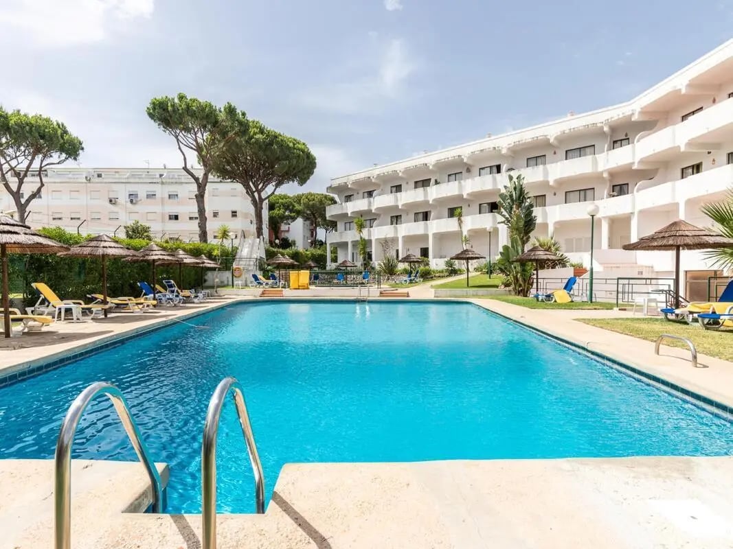 Pool area with lounge chairs and buildings exterior at Elegant 1-bedroom apartment in Vilamoura in Quarteira Student Accommodation