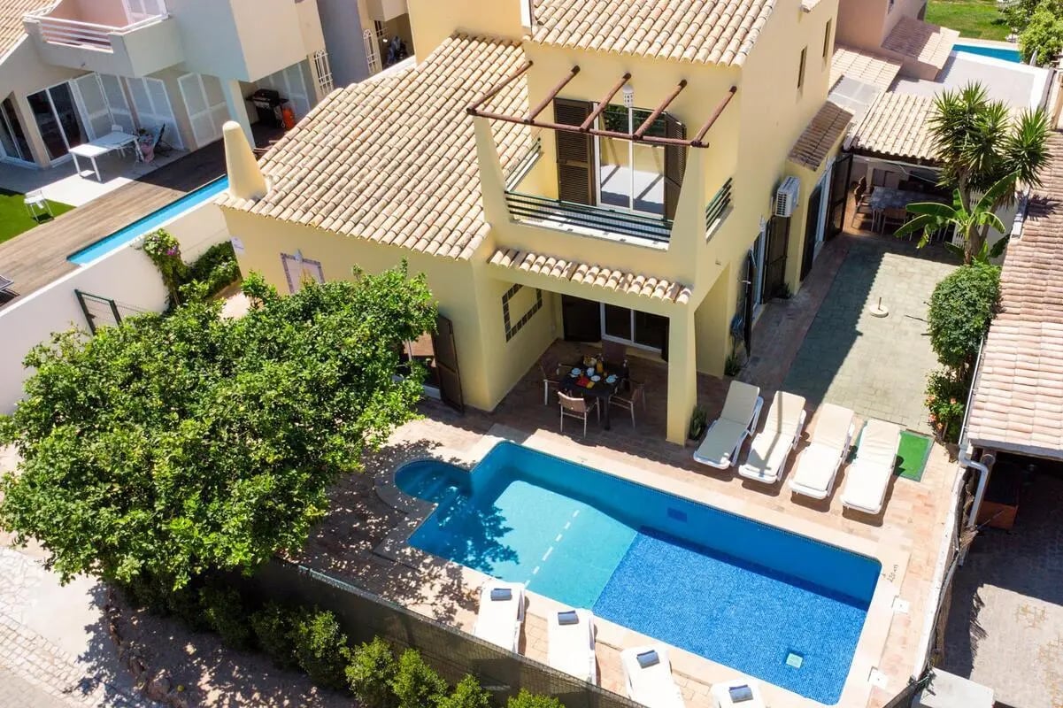 Villa with pool loungers and dining area exterior at Charming house in Vilamoura in Vilamoura Student Accommodation