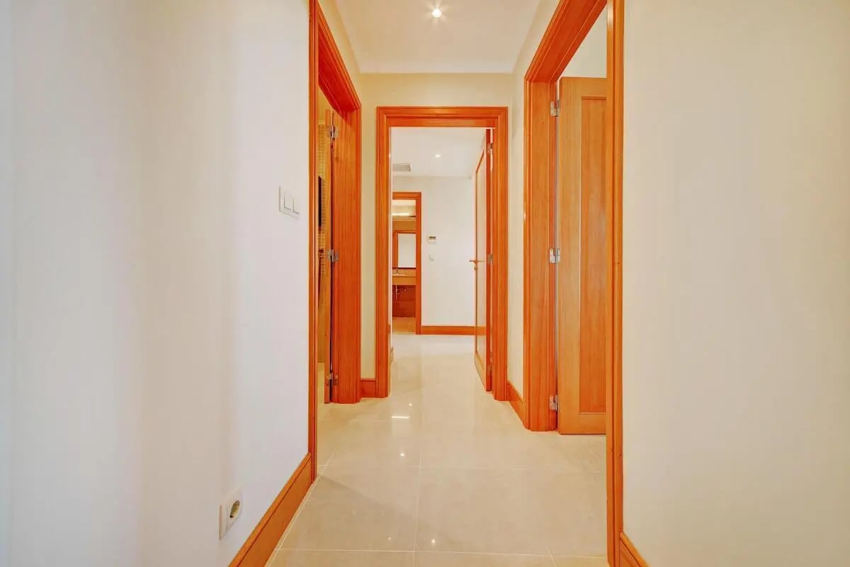Interior hallway with wooden doors and tiled floor hallway at Elegant 2-bedroom flat in sunny Vilamoura in Quarteira Student Accommodation