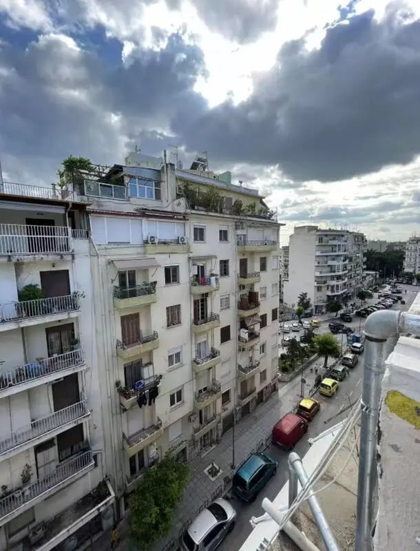 Apartment building with balconies and parked cars exterior at Homely Double Bedroom with a balcony close to Aristotelous Square in Thessaloniki Student Accommodation
