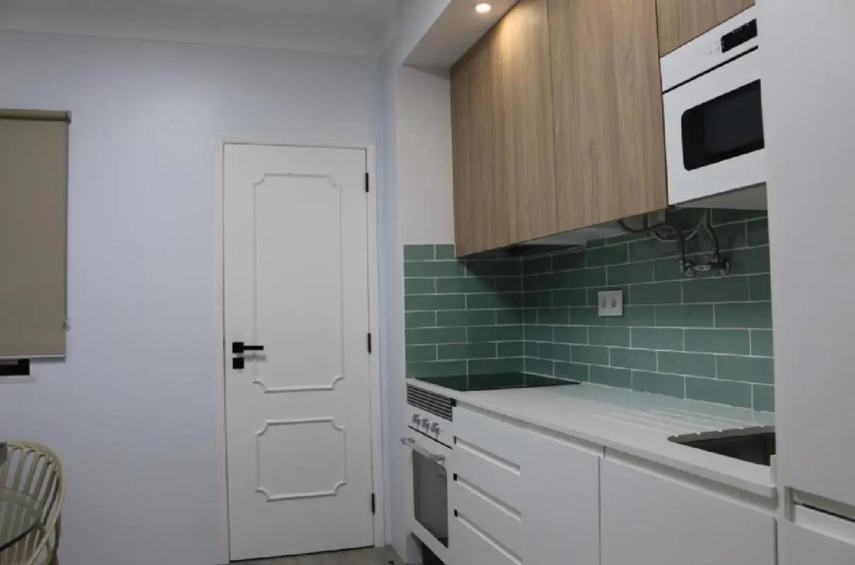 White cabinets stove oven and microwave kitchen at Welcoming 2 Bedroom Apartment with a balcony close Angrinha Beach to in Lagoa Student Accommodation
