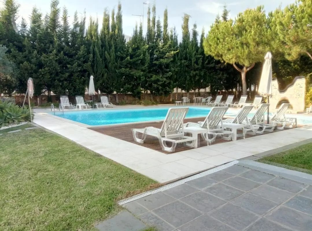 Pool area with lounge chairs and trees exterior at Welcoming 2-bedroom apartment with garden and pool in Tavira Student Accommodation