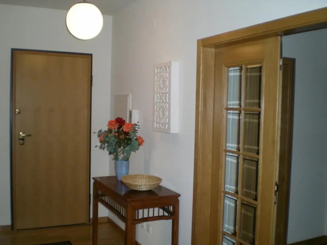 Wooden door flowers on table decorative panel entryway. at 2-bedroom apartment, with outdoor area and pool in Tavira Student Accommodation