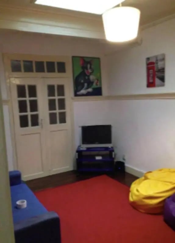 Blue sofa red carpet TV bean bags living room at Nice single bedroom in Covilhã in Covilha Student Accommodation