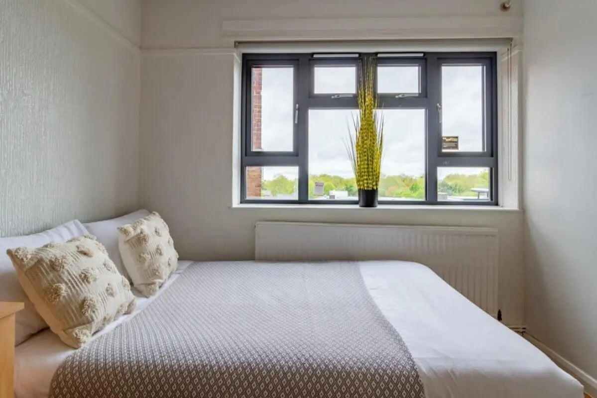 Bed with textured pillows and grey throw Bedroom at Surrey Quays Landale House in London Student Accommodation