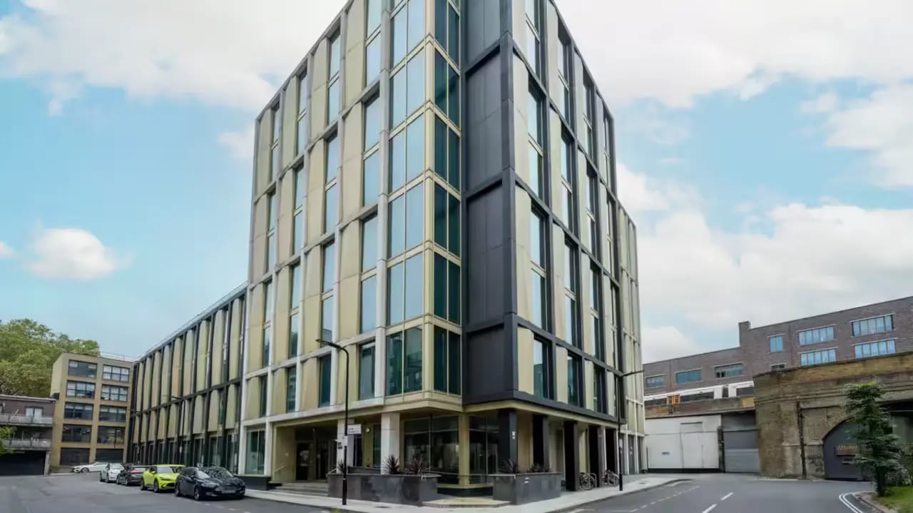 Modern student accommodation building with cars outside exterior at Flora Building - Hoxton in London Student Accommodation