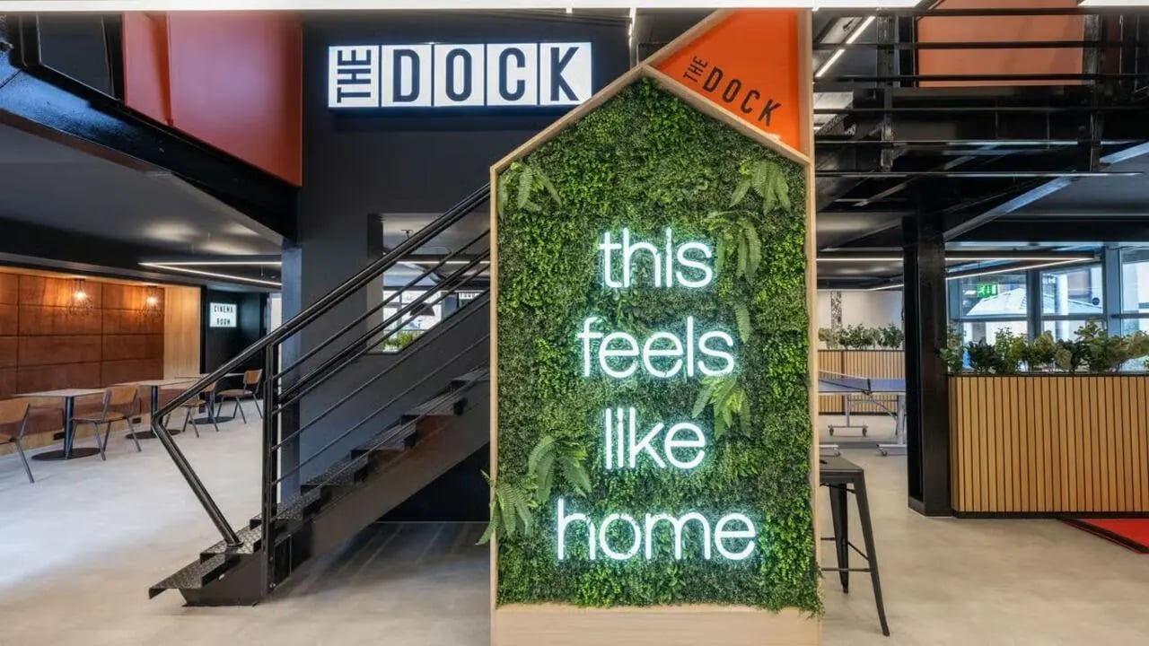 Green living wall with neon text and stairs communal area at Clarence Dock Village in Leeds Student Accommodation