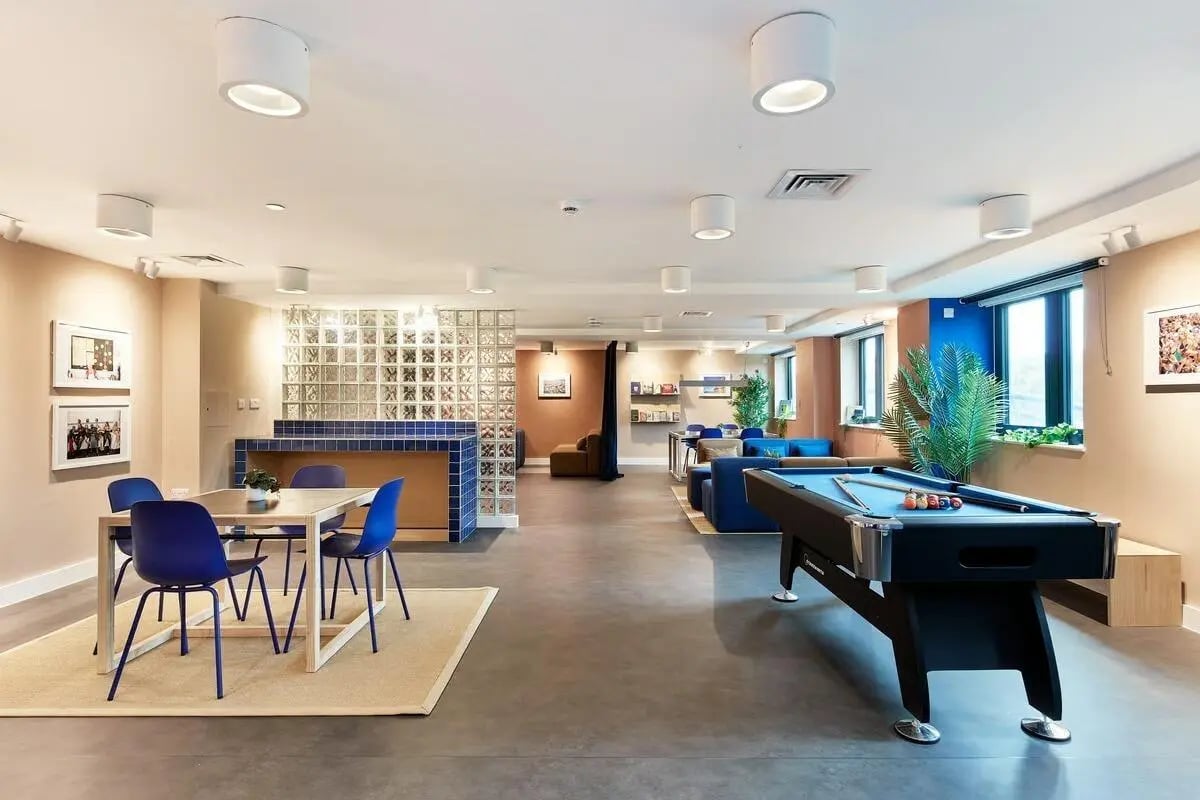 Pool table dining table and blue chairs communal area at Hollis Wharf in Bath Student Accommodation