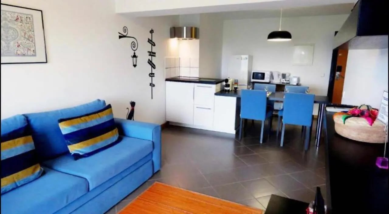 Blue sofa with striped pillows kitchen area living room at Charming 1-bedroom flat in Portimão in Portimão Student Accommodation