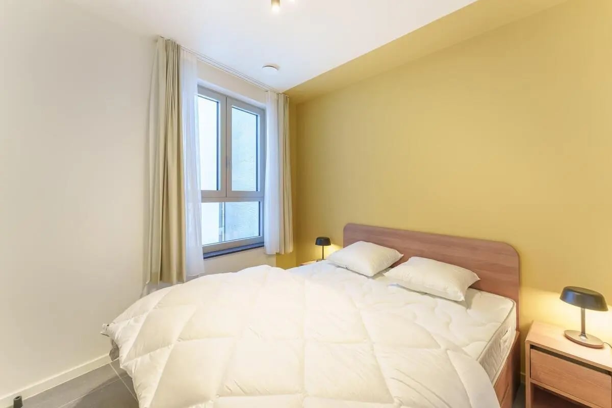 Bed pillows window and side table Bedroom at Neat 1 bedroom apartment near Antwerp central station in Antwerp Student Accommodation
