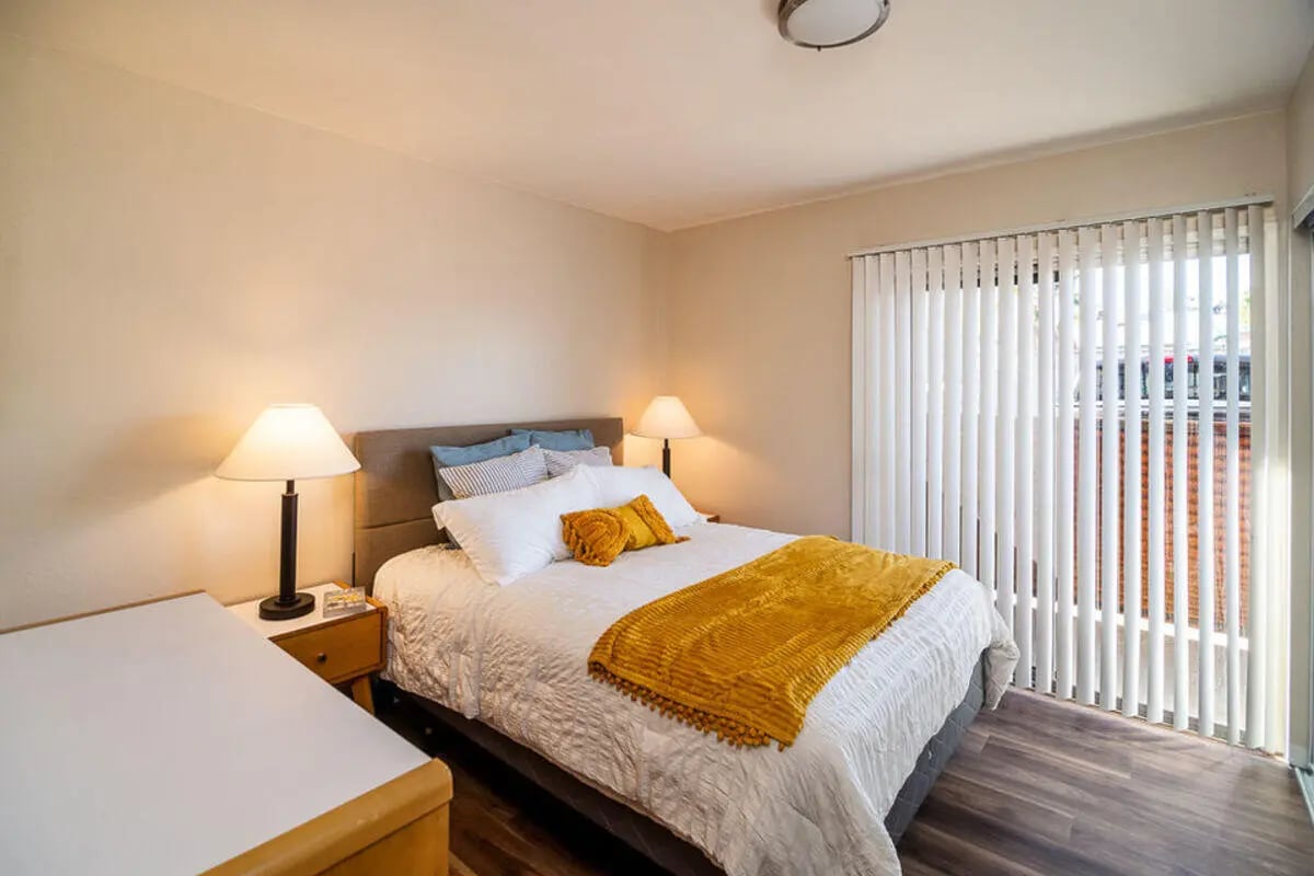 Bed with yellow blanket bedside lamps bedroom at Union on Bellevue in Tucson Student Accommodation
