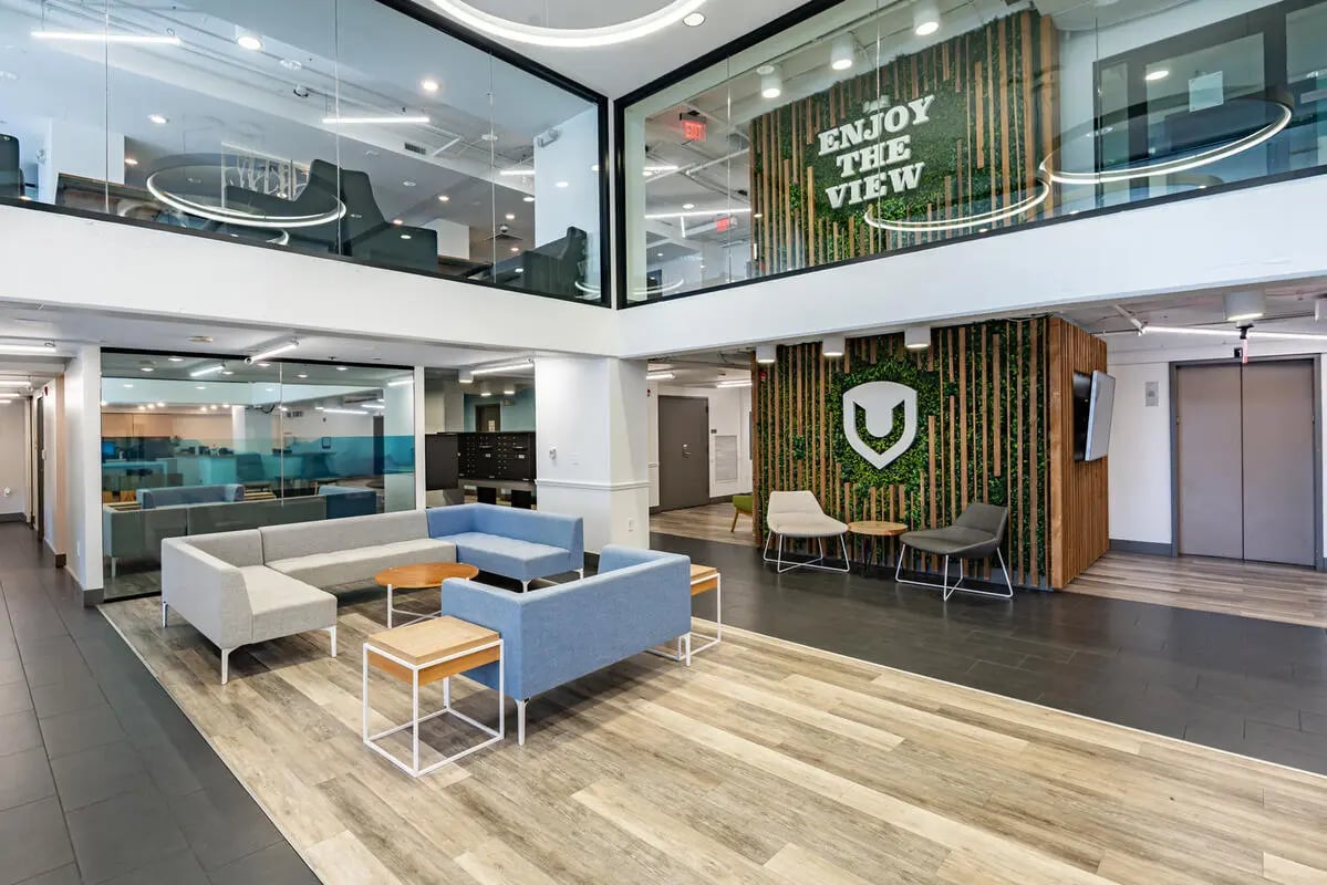 Modern lounge with sofas tables and green wall living area at A University View in Tallahassee Student Accommodation