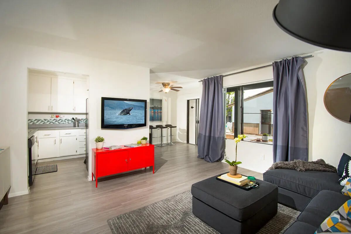 Kitchen cabinets TV red cabinet bar stools living room at University Crest Apartments in Riverside Student Accommodation