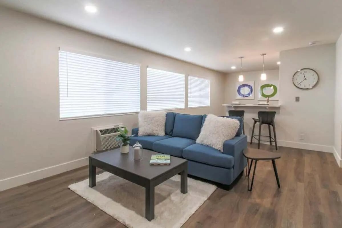 Blue couch with white pillows coffee table bar living room at Aero Apartments in Davis Student Accommodation