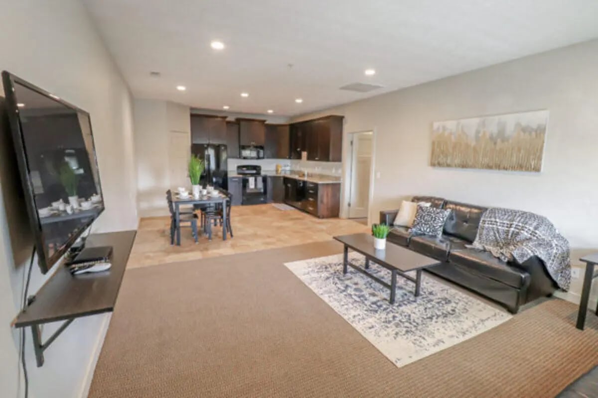 Black couch coffee table dining set kitchen living room at CollegePlace Woodland in Provo Student Accommodation