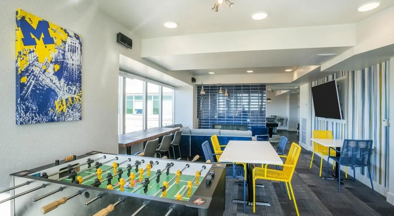 Foosball table artwork tables chairs and sofa living room at Sterling Arbor Blu in Ann Arbor Student Accommodation