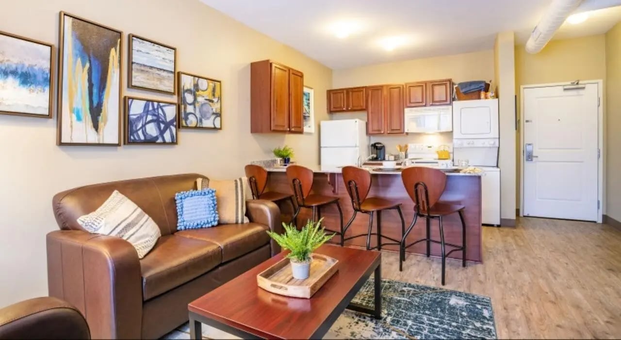 Leather sofa coffee table art paintings kitchen living room at The Courtyards Student Apartments in Ann Arbor Student Accommodation