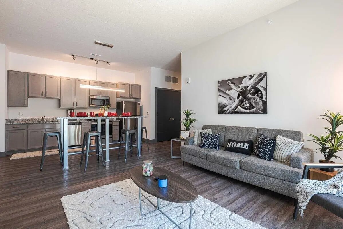 Sofa coffee table kitchen island and stools living room at The Flight at Dayton in Dayton Student Accommodation