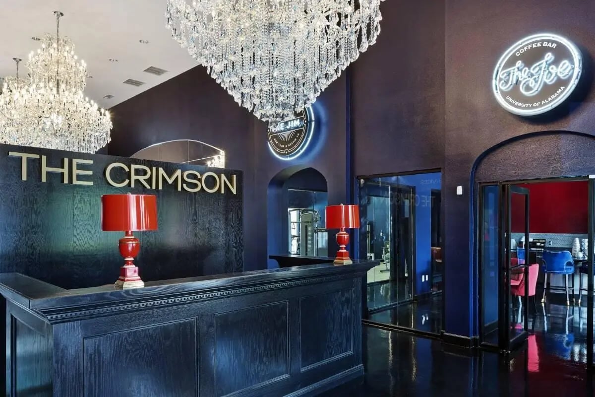 Lobby desk chandeliers neon signs coffee bar entrance lobby at Crimson in Tuscaloosa Student Accommodation