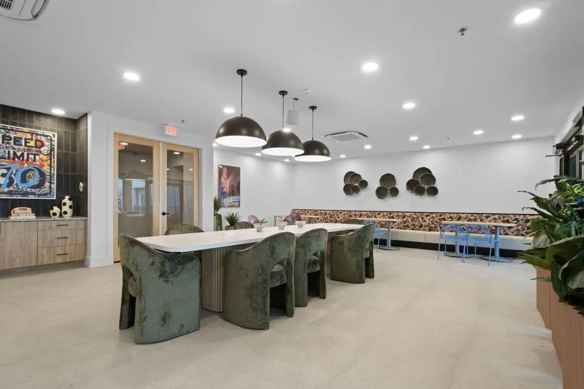 Dining table with green chairs and art decor. at UNITi Bishop Arts in Dallas Student Accommodation