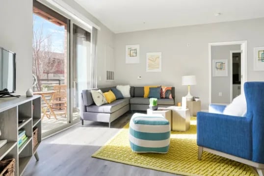 Grey sectional sofa balcony with table and chairs living room at The Province Boulder in Boulder Student Accommodation