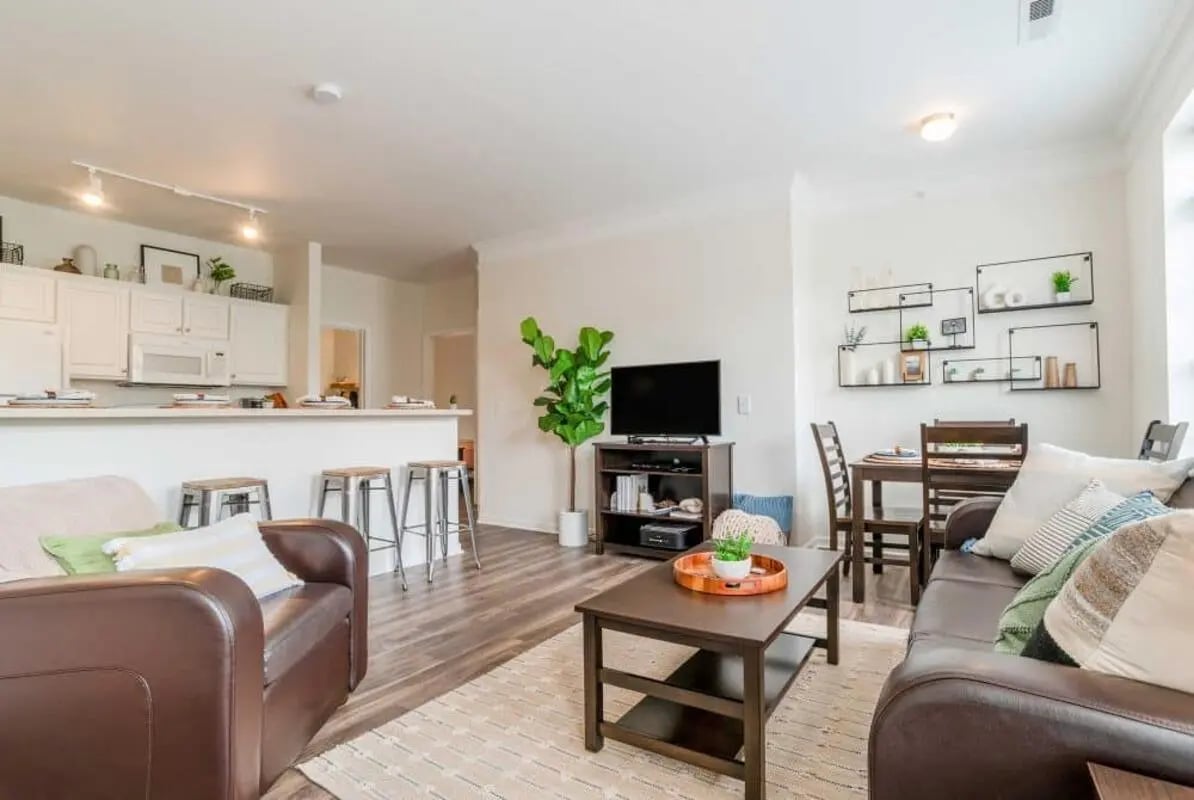 Brown sofas coffee table dining set living room at The Province Greensboro in Greensboro Student Accommodation