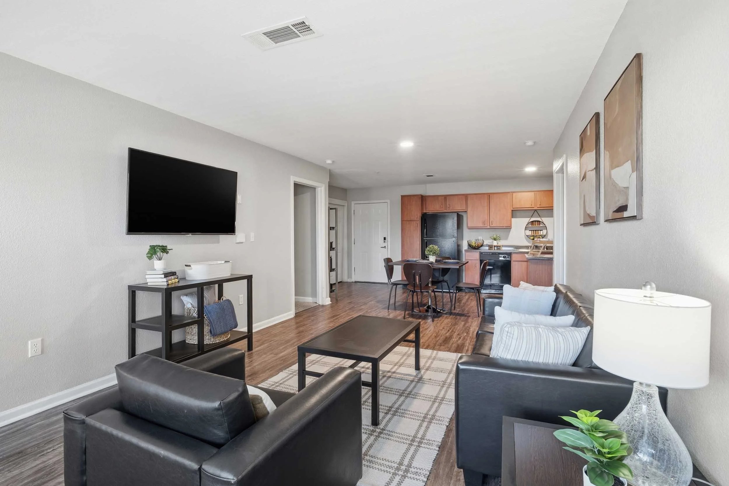 Two black sofas coffee table and kitchen living room at Altitude Baton Rouge | Apartment Complex in Baton Rouge Student Accommodation