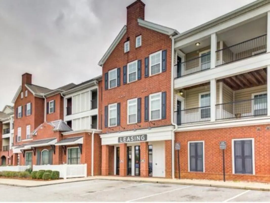 Brick building with balconies and leasing office exterior at East Edge in Tuscaloosa Student Accommodation