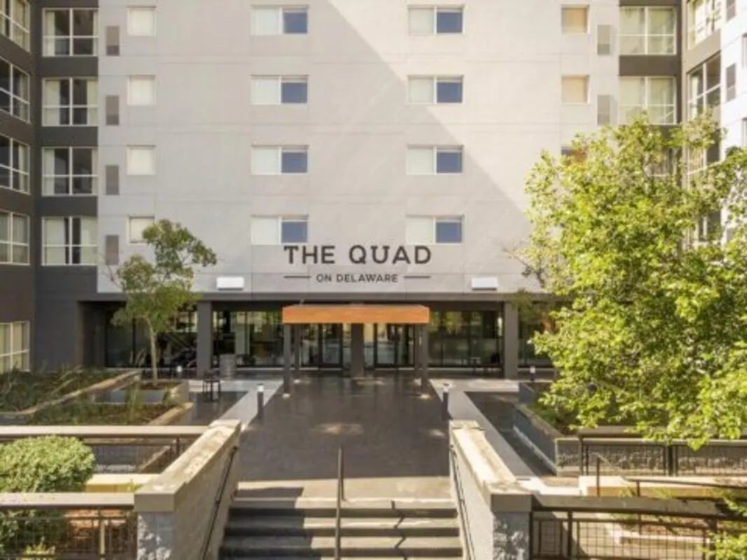Building entrance with large windows and trees exterior at The Quad On Delaware in Minneapolis Student Accommodation