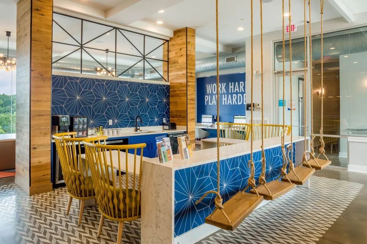 Blue geometric wall swings yellow chairs study area at The Bluff at Waterworks Landing in Tuscaloosa Student Accommodation