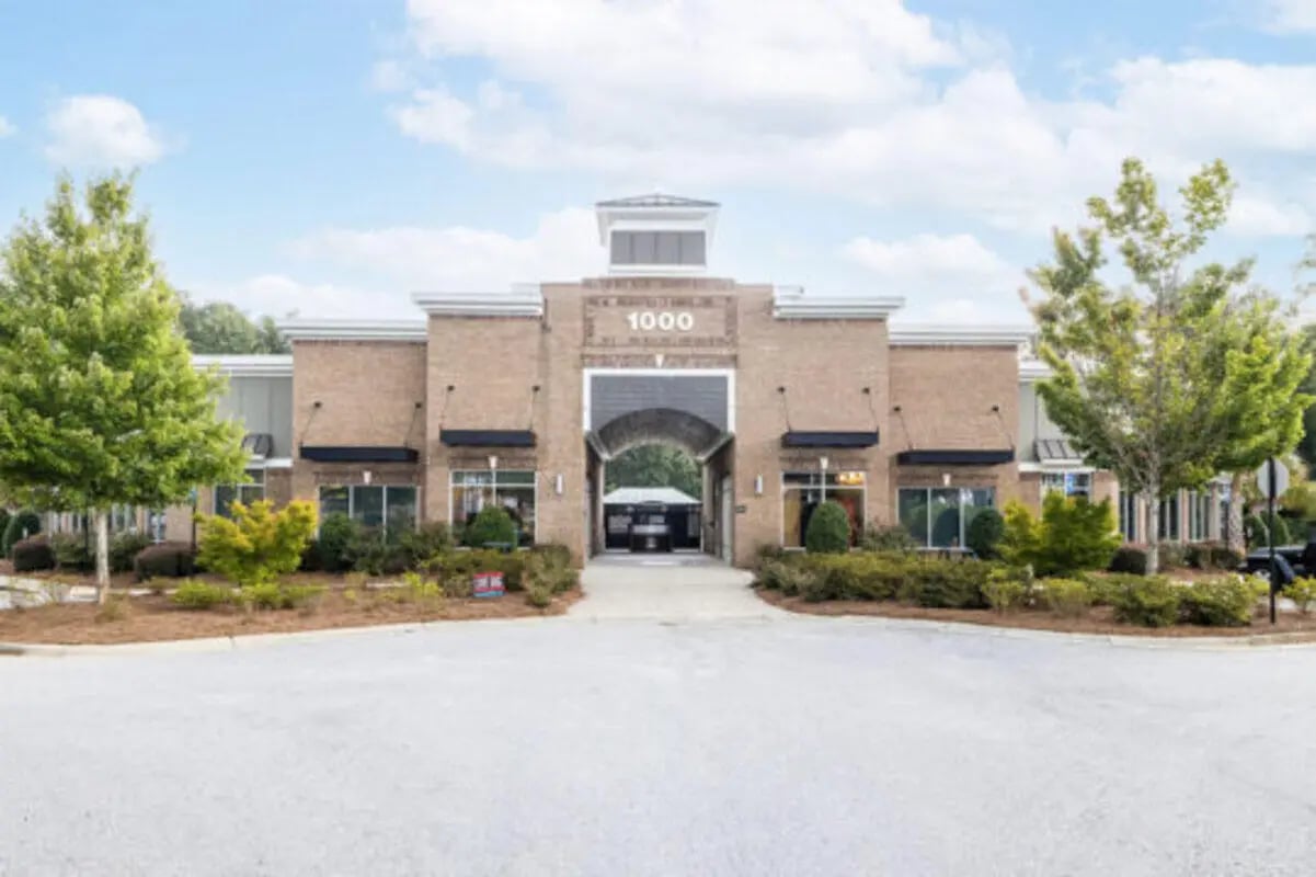 Brick building with arched entrance and trees exterior at Athens Ridge in Athens Student Accommodation