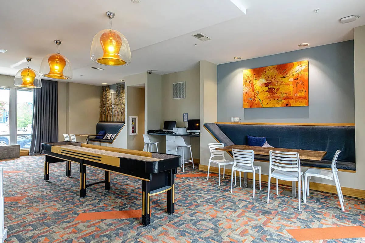 Shuffleboard tables seating computers and artwork common area at The Dillon in Bloomington Student Accommodation