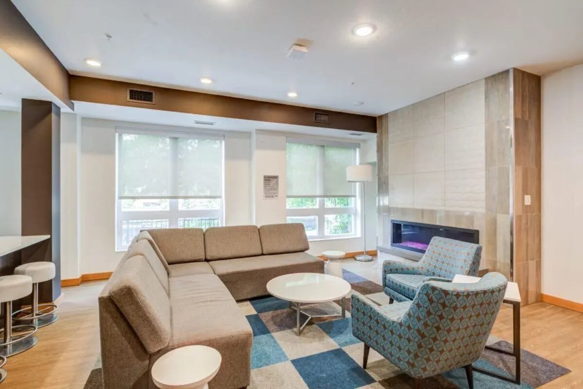 Sectional sofa with patterned chairs fireplace living room at The Knoll Dinkytown in Minneapolis Student Accommodation