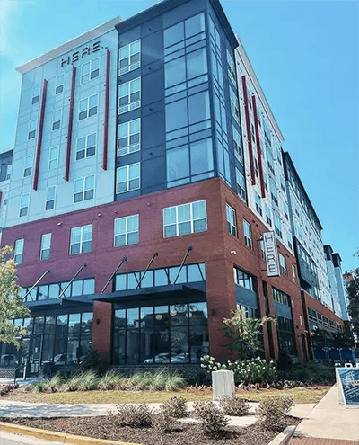 Modern building with brick and glass facade exterior at Here Tuscaloosa in Tuscaloosa Student Accommodation
