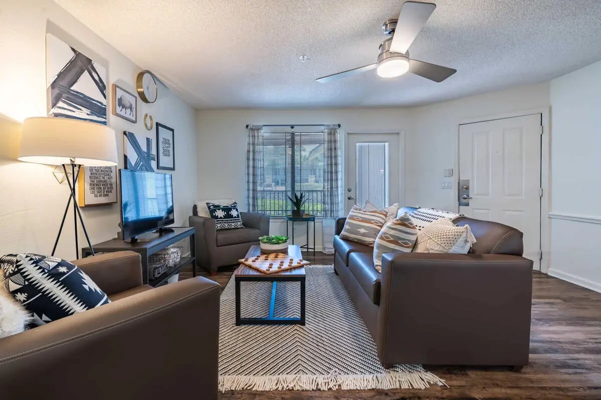 Leather couches and chairs with throw pillows living room at Hideaway Gainesville in Gainesville Student Accommodation